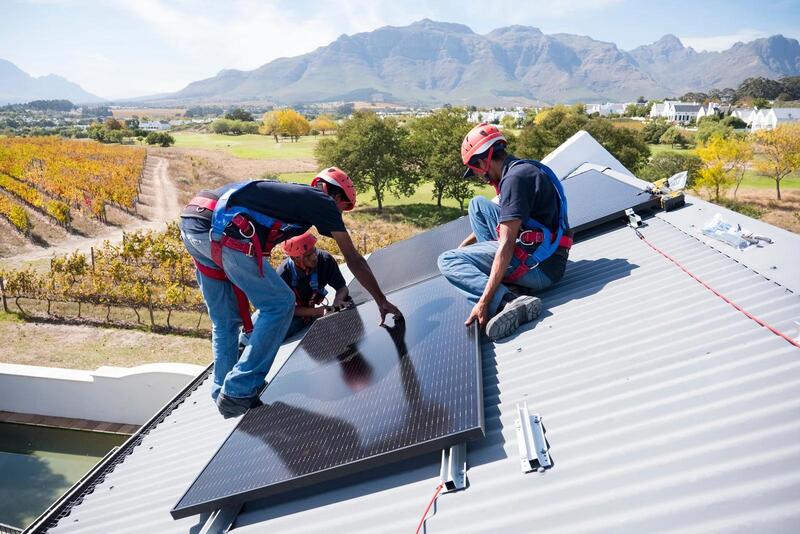 ช่างไฟฟ้ากำลลังติดตั้งแผงโซล่าเซลล์บนหลังคา"